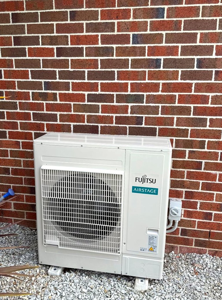Fujitsu Airstage outdoor unit on brick wall