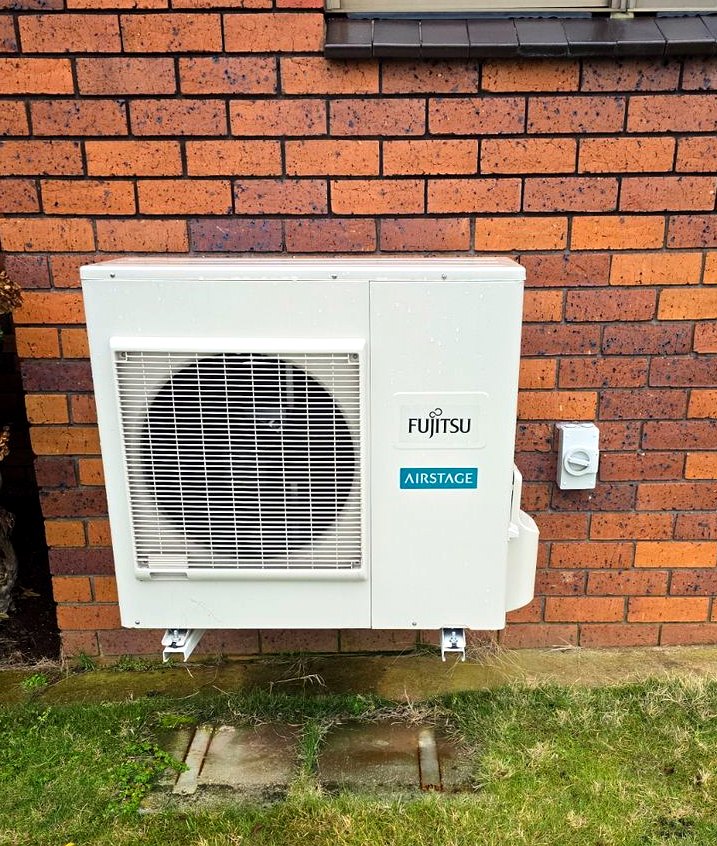 Fujitsu outdoor heat pump on brick wall